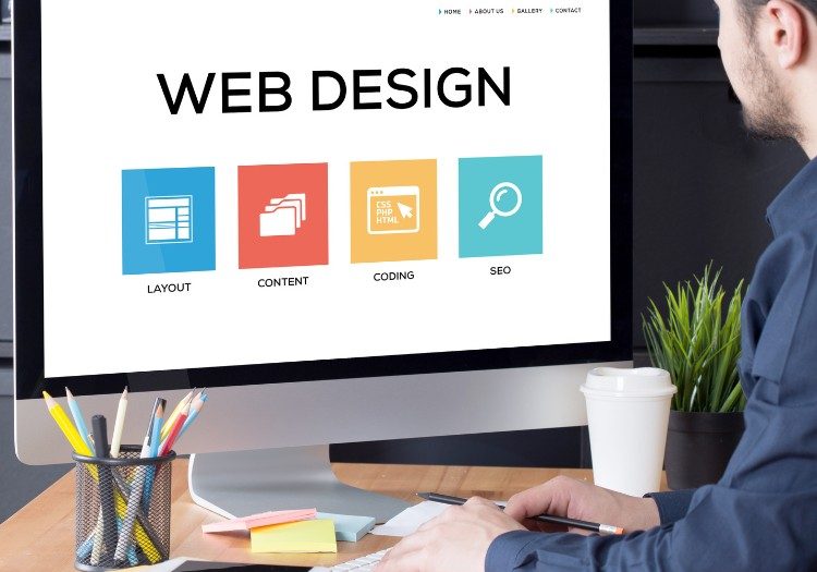 man designing a website on a large screen